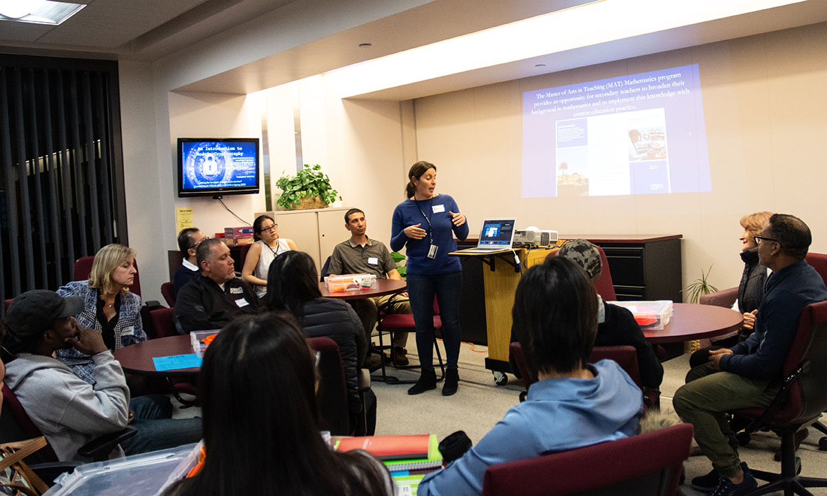 Math faculty teaching a group of participants; showing a powerpoint